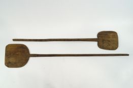 Two bakers long handled wooden bread oven shovels,