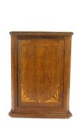 A George III oak hanging corner cabinet with mahogany inlay and cross banding,