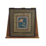 Two framed Chinese silk embroideries, each with a central flower spray on a blue ground,