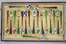 A group of eighteen gilt metal polychrome enamel decorated coffee spoons with floral motifs