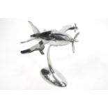 An aluminium aeroplane in the Art Deco style with three moving propellors, on an oval base,