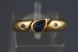 A yellow metal three stone dress ring set with sapphires and diamonds.