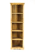A narrow pine standing bookcase with five shelves flanked by split turned mouldings,
