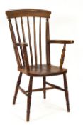A 19th century stick back elbow chair with elm solid seat on turned legs