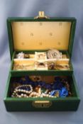 A green jewellery case with assorted jewellery to include beads, bracelets,
