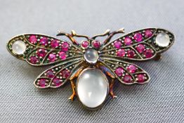 A yellow and white metal butterfly brooch set with cabochon cut moonstones
