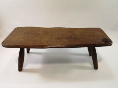 A Cotswold School style elm coffee table with natural plank shaped top,