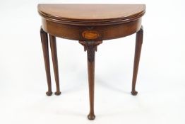 A George III mahogany card table, of demi lune form, with a plain apron,