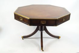 A 20th century mahogany and brass bound octagonal drum table with leather inset top on four splayed