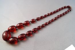 A single strand of red faceted graduated beads.