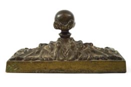 A 19th century brass and cast iron filled door stop with ball finial,
