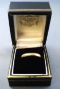 A yellow metal D shaped wedding ring (cut off through hallmark).