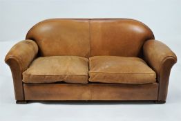 A leather two seat sofa with two loose cushions on block feet,