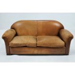 A leather two seat sofa with two loose cushions on block feet,