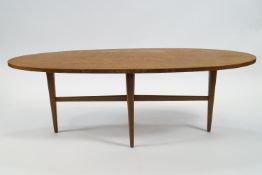 An oval coffee table, designed by Gordon Russell, on turned tapering legs,