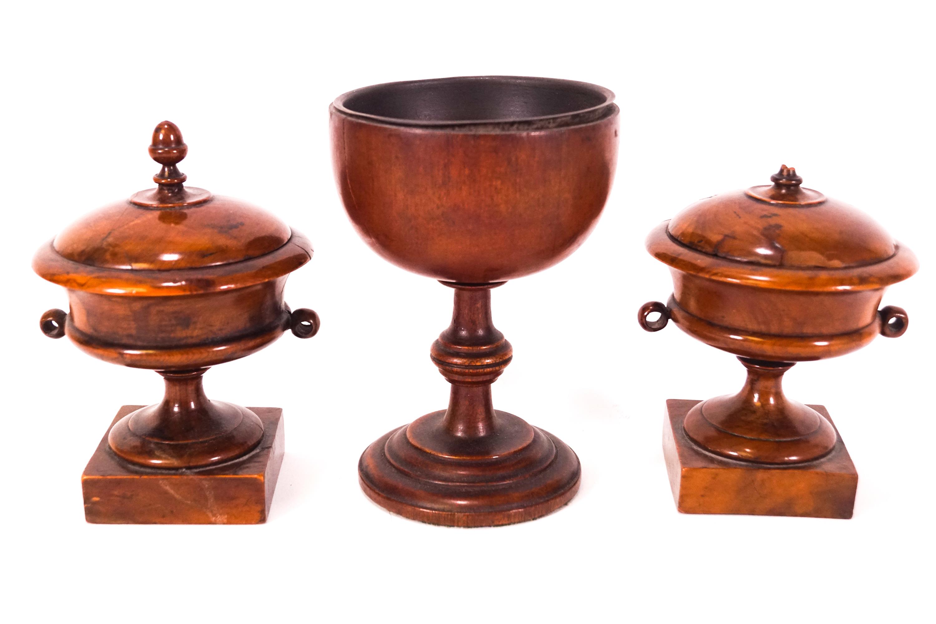 A pair of 19th century turned yew urns and covers, on square plinth bases, 13cm high,