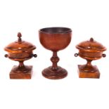 A pair of 19th century turned yew urns and covers, on square plinth bases, 13cm high,