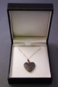 A yellow and white metal heart pendant grain set with single cut diamonds.