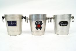 Three champagne buckets, each with two ring handles and labelled Moet & Chandon,