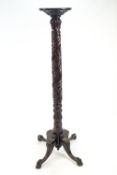 A mahogany torchere on four scroll legs, carved with ball and claw feet,