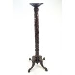 A mahogany torchere on four scroll legs, carved with ball and claw feet,