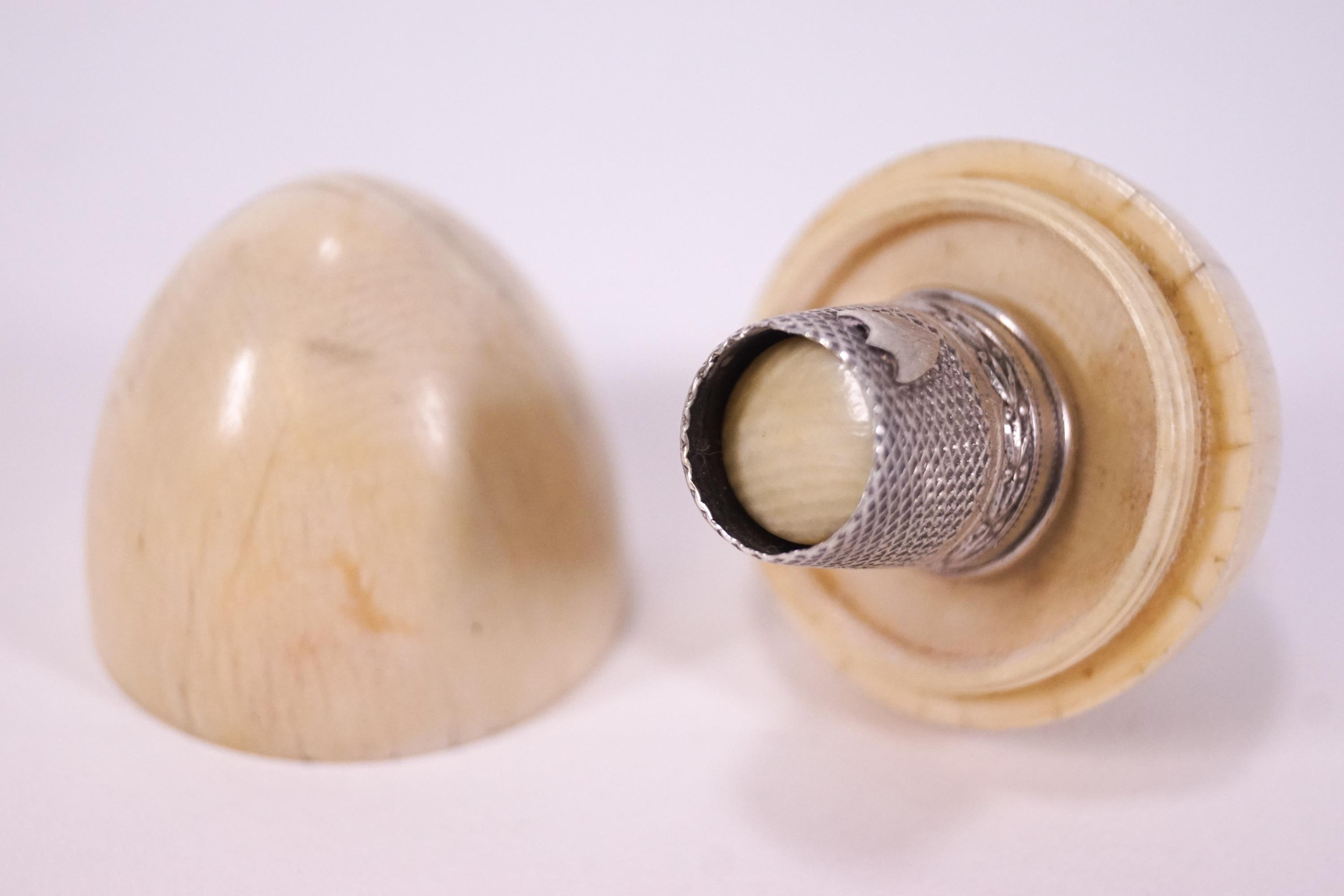 A 19th century turned ivory egg shaped thimble case with a white metal thimble,