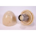 A 19th century turned ivory egg shaped thimble case with a white metal thimble,