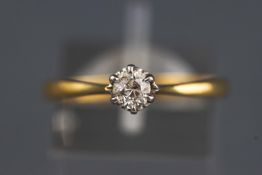 A yellow and white metal single stone ring set with a round brilliant cut diamond