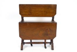 An Edwardian mahogany two tier Sutherland table on turned supports,