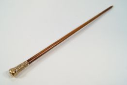 A malacca walking cane with embossed gilt metal pommel.
