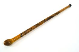 A Japanese bamboo walking stick, carved with a Samurai and a carp, in a rocky landscape,