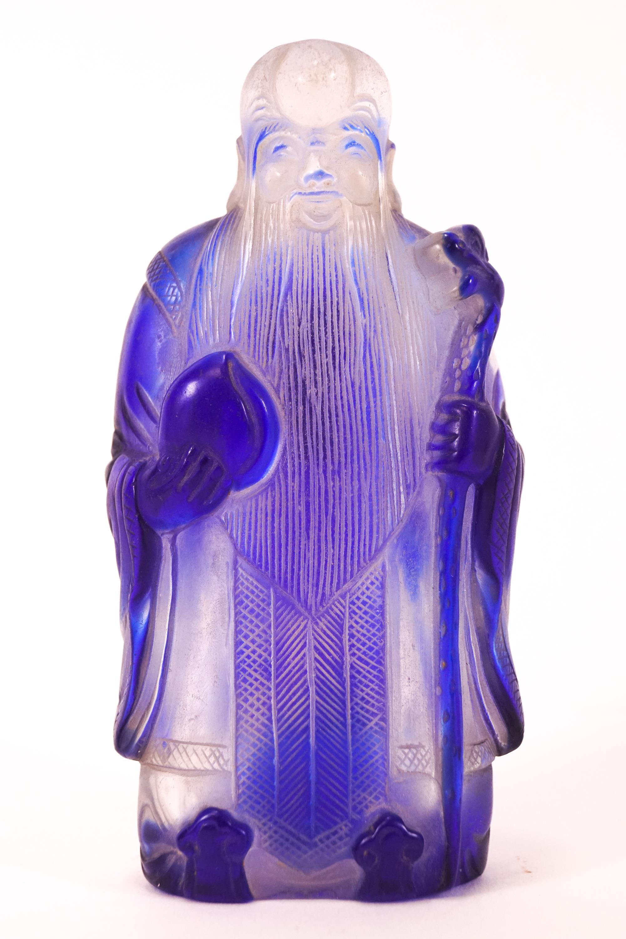 A clear glass with blue overlay Chinese snuff bottle in the form of a sage,