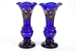 A pair of blue glass baluster form vases with frilled tops,