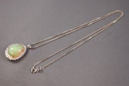 A white metal cluster pendant set with a pear cabochon cut opal of approximately 10.