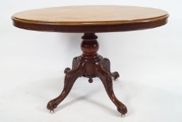 A late 19th century mahogany loo table on turned pedestal issuing four carved cabriole legs,