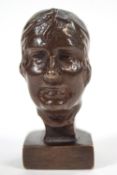 A bronze bust of a lady, of miniature form, depicted wearing a knotted headscarf,