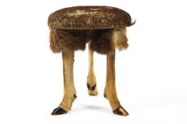 A deer skin stool, supported on three deer slots,