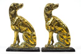 A pair of 19th century brass door porters of seated hounds,