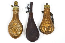 Two copper and brass shot and powder flasks, one decorated with horses,