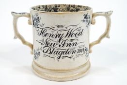 A pottery mug with two handles, ex The New Inn, Blagdon 1874,