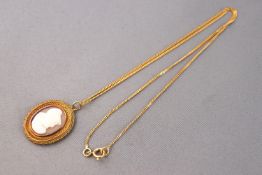 A yellow metal oval carved cameo pendant with beaded finish, tests indicate 18ct gold,