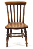 A small stick back chair with solid elm seat on turned legs linked by a stretcher,