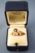 A collection of two yellow metal dress rings consisting of a three stone claw set ruby and old cut