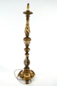 A carved wooden standard lamp base, with foliate details and gilded highlights,