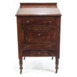 A Victorian and later mahogany clerks desk on turned legs with brass and ceramic casters,