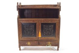 A Victorian palm wood hanging cabinet with two shelves above two carved panelled doors