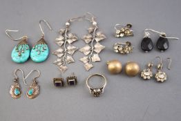 A collection of eight pairs of silver earrings of variable designs