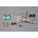 A collection of eight pairs of silver earrings of variable designs