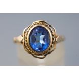 A yellow metal single stone ring, set with an oval blue glass gem, hallmarked 9ct gold, Birmingham.