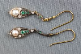 A yellow and white metal pair of drop earrings, set with emeralds, diamonds and a freshwater pearl.